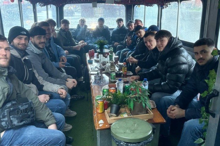 Group of people sitting around a table inside a bus.