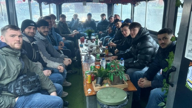 Group of people sitting around a table inside a bus.